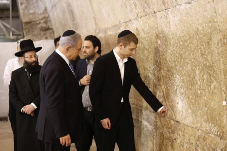 Ο Ισραηλινός πρωθυπουργός Μπενιαμίν Νετανιάχου και ο γιος του Γέαρ αφήνουν σημείωμα στο Δυτικό Τείχος, στην Ιερουσαλήμ (φωτ.: EPA/ABIR SULTAN)
