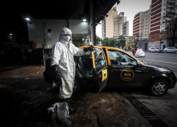 Προσωπικό απολυμαίνει ένα ταξί (φωτ.: EPA/Juan Ignacio Roncoroni)