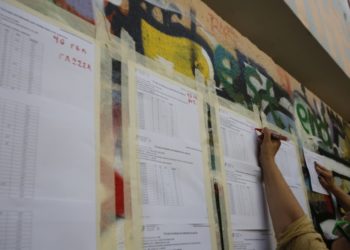 Μέλη του διδακτικού προσωπικού αναρτούν τους πίνακες με τις βαθμολογίες των υποψηφίων των Πανελλαδικών Εξετάσεων, έξω από το σχολικό συγκρότημα της Γκράβας στο Γαλάτσι (φωτ.: ΑΠΕ-ΜΠΕ/Αλέξανδρος Βλάχος)
