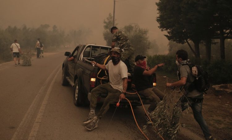Πολίτες επιβιβάζονται σε υδροφόρο όχημακατά τη διάρκεια της επιχείρησης κατάσβεσης της πυρκαγιάς,στο Πευκί, στη βόρεια Εύβοια (φωτ.:: ΑΠΕ-ΜΠΕ/Κώστας Τσιρώνης)