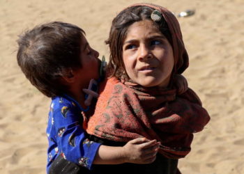Δύο παιδία πρόσφυγες από το Αφγανιστάν μέσα στις προσφυγικές ροές (φωτ.: EPA/ Muhammad Sadiq)
