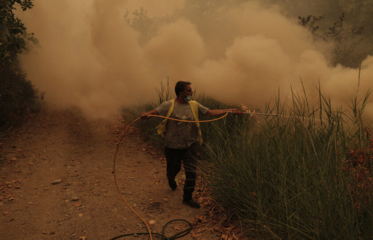 Κάτοικος επιχειρεί στην κατάσβεση της πυρκαγιάς στο χωριό Γούβες στην Εύβοια, Κυριακή 08 Αυγούστου 2021 (φωτ.: ΑΠΕ-ΜΠΕ/ Κώστας Τσιρώνης)