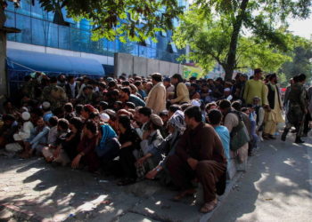 Άνθρωποι περιμένουν μπροστά από τράπεζα στην Καμπούλ (φωτ.: EPA/ STRINGER)