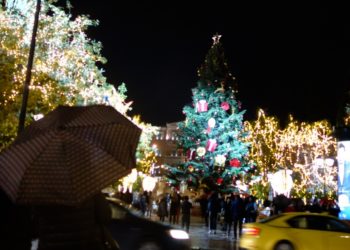 Εικόνα από την Πλατεία Συντάγματος όπου, την Τρίτη το βράδυ, έγινε η φωταγώγηση του χριστουγεννιάτικου δέντρου παρουσία πολιτών που έμειναν εκεί παρά τη βροχή (φωτ.: Γιώργος Κονταρίνης/ EUROKNISSI)