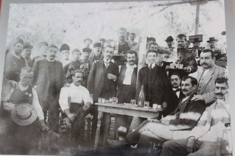 Η φωτογραφία απεικονίζει γλέντι που οργανώθηκε από τα μέλη του Εθνικού Κομιτάτου της Απελευθέρωσης 1912 προς τιμήν του καπετάν Δημήτρη Τσακίρη, για τη δράση του ως οπλαρχηγού αντάρτικου σώματος 60 ανδρών, του μόνου αναγνωρισμένου από την κυβέρνηση, που έλαβε μέρος στη Μάχη του Κλαπάδου (φωτ.: Λέσχη Πλωμαρίου Βενιαμίν ο Λέσβιος)