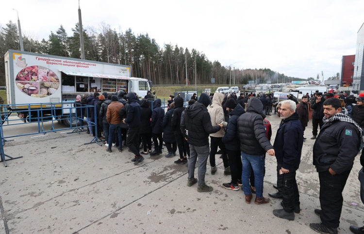 Πρόσφυγες και μετανάστες περιμένουν στην ουρά για φαγητό σε καντίνα στο λευκορωσικό χωριό Μπρούζγκι, κοντά στα σύνορα της Πολωνίας (φωτ.: BelTA / Maxim Guchek)