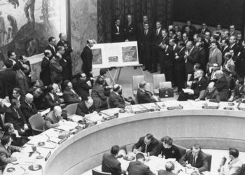O Αμερικανός πρεσβευτής Αντλέ Στίβενσον ΙΙ στον ΟΗΕ δείχνει αεροφωτογραφίες ρωσικών πυραύλων στην Κούβα, κατά τη διάρκεια συνεδρίασης του Συμβουλίου Ασφαλείας του ΟΗΕ, στις 25 Οκτωβρίου 1962, παρουσία του τότε πρεσβευτή της Ρωσίας Βαλέριαν Ζόριν (φωτ.: en.wikipedia.org)