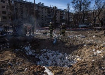 Μέλη σωστικών συνεργείων σε βομβαρδισμένο συγκρότημα κατοικιών στα περίχωρα του Κιέβου (φωτ.: EPA / Roman Pilipey)
