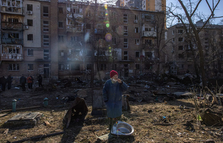 Ουκρανή έξω από βομβαρδισμένο συγκρότημα κατοικιών στα περίχωρα του Κιέβου (φωτ.: EPA / Roman Pilipey)