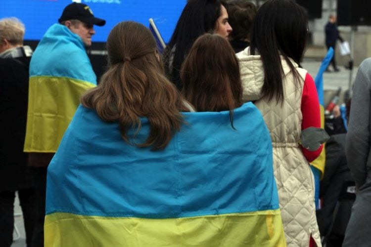Ουκρανοί με σημαίες είναι συγκεντρωμένοι στην πλατεία Κοτζιά για να παρακολουθήσουν σε γιγαντοοθόνη τον τηλεμαραθώνιο #stopwar, για την υποστήριξη της Ουκρανίας. (φωτ.: ΑΠΕ-ΜΠΕ/Αλέξανδρος Μπελτές)
