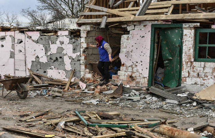 Γυναίκα στο κατεστραμμένο της σπίτι σε χωριό της περιφέρειας του Κιέβου (φωτ.: EPA / Oleg Petrasyuk)