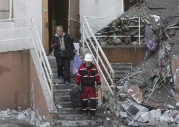 Ένας διασώστης βοηθά έναν άνδρα να μεταφέρει τα πράγματά του, μετά τους χθεσινούς βομβαρδισμούς στην Οδησσό (φωτ.:  EPA/ Stepan Franko)