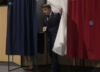 Ο Γάλλος πρόεδρος Εμανουέλ Μακρόν εξέρχεται από τον εκλογικό θάλαμο, κατά το χθεσινό, δεύτερο γύρο των βουλευτικών εκλογών στη Γαλλία (φωτ.: EPA/ Michel Spingler / POOL)