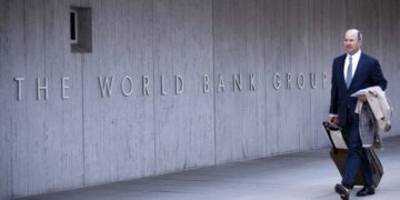 Ένας πεζός περπατά μπροστά από το κτήριο της Παγκόσμιας Τράπεζας, στην Ουάσινγκτον. (φωτ. αρχείου: EPA/ Shawn Thew)