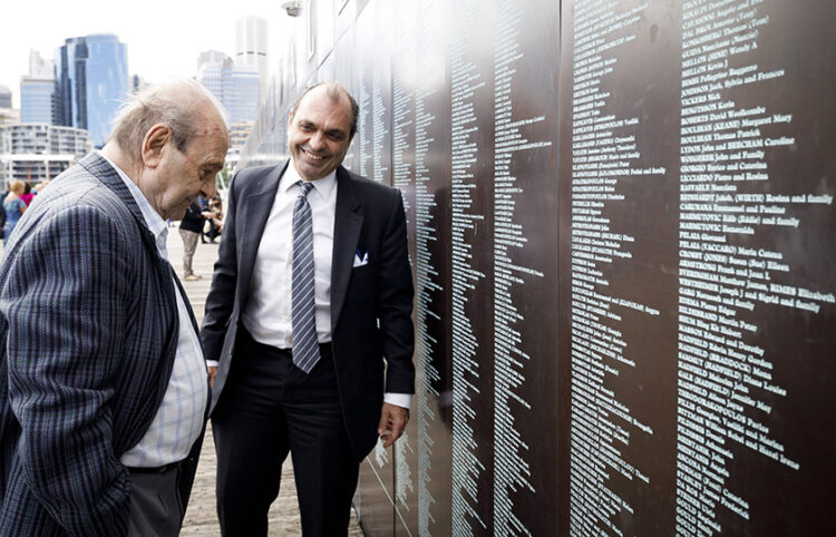 Ο Εμμανουήλ Αλφιέρης, πρόεδρος της Κυθηραϊκής Ένωσης Αυστραλίας, και ο πατέρας του Γιώργος στο Εθνικό Μνημείο Μετανάστευσης στο Σίδνεϊ, στο οποίο αναγράφονται τα ονόματα όλων των μεταναστών (φωτ: Australian National Maritime Museum / Marinco Kojdanovski)