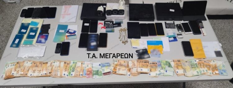 Χρήματα, κοσμήματα κινητά τηλέφωνα κι άλλα αντικείμενα που κατασχέθηκαν σε επιχείρηση εξάρθρωσης εγκληματικής οργάνωσης που διέπραττε ηλεκτρονικές απάτες (Φωτ.: astynomia.gr)