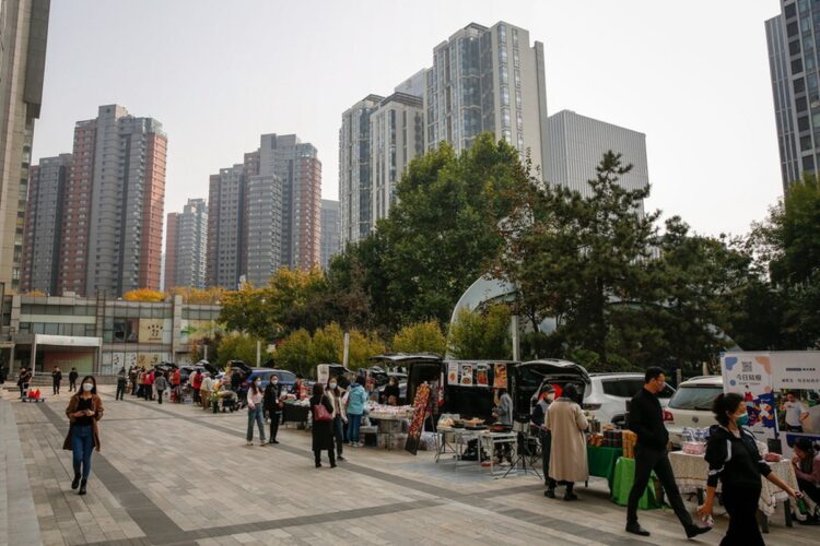 Κόσμος περπατά σε υπαίθρια αγορά στο Πεκίνο (Φωτ.: EPA/Mark R. Cristino)