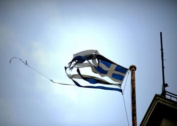 Σκισμένη σημαία κυματίζει από τον αέρα σε κτήριο της Αθήνας (φωτ.: EUROKINISSI / Στέλιος Μισίνας)