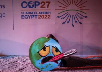Ακτιβίστρια στη Διάσκεψη των Ηνωμένων Εθνών για το Κλίμα (COP27),  που γίνεται στο Σαρμ ελ Σέιχ της Αιγύπτου  κρατά κατασκευή που δείχνει τη γη να έχει πυρετό (Φωτ.: EPA/Sedat Suna)