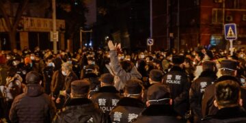 Διαδηλωτές στο Πεκίνο διαμαρτύρονται, υπό τα βλέμματα των αστυνομικών, για την πολιτική «μηδενικής covid»(Φωτ.: EPA/Mark R. Cristino)