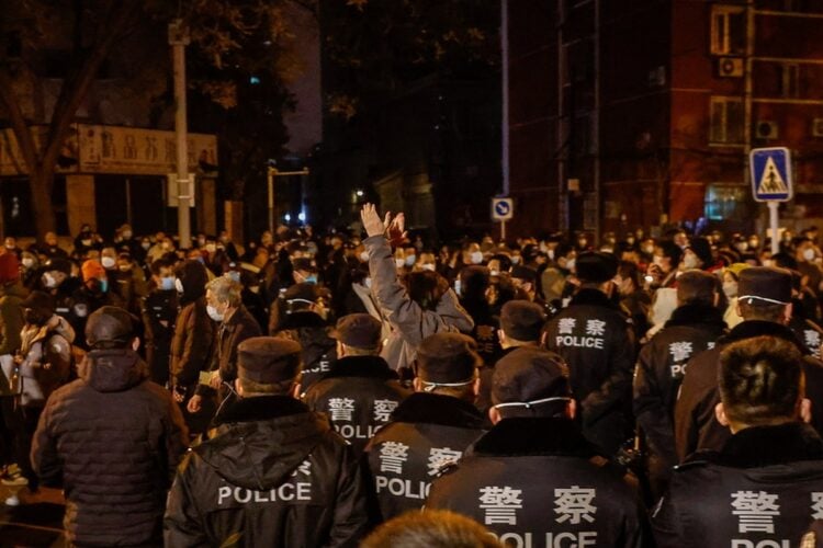 Διαδηλωτές στο Πεκίνο διαμαρτύρονται, υπό τα βλέμματα των αστυνομικών, για την πολιτική «μηδενικής covid»(Φωτ.: EPA/Mark R. Cristino)