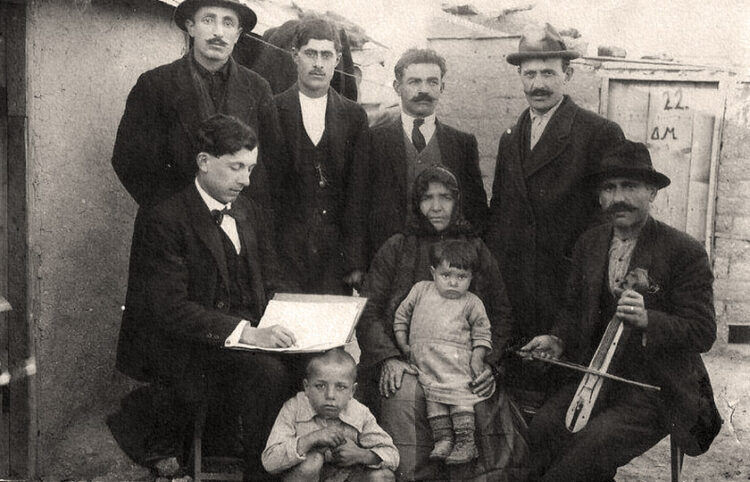 Ο Δ. Κουτσογιαννόπουλος (καθιστός, αριστερά) στη Δραπετσώνα, το 1921, καταγράφει ποντιακά τραγούδια από πρόσφυγες (φωτ.: αρχείο Κατερίνας Κουτσογιαννοπούλου)