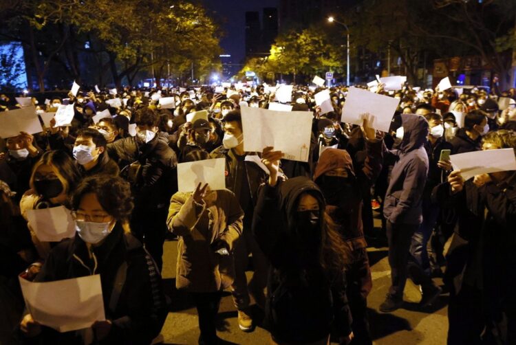 Πολίτες διαδηλώνουν στο Πεκίνο κρατώντας λευκές κόλλες χαρτί, στη διάρκεια διαμαρτυρίας για το θάνατο 10 ανθρώπων σε πυρκαγιά που ξέσπασε σε κτήριο στην πόλη Ουρούμτσι (φωτ.: EPA/Mark R. Cristino)
