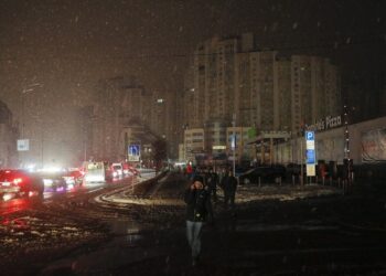 Κάτοικοι του Κιέβου περπατούν στους σκοτεινούς δρόμους καθώς η ηλεκτροδότηση έχει διακοπεί μετά από ρωσικές πυραυλικές επιθέσεις (Φωτ.: EPA/Sergey Dolzhenko)