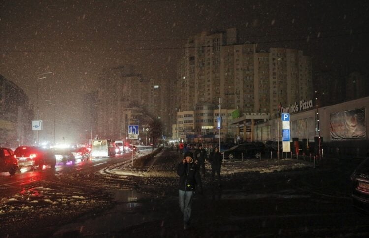 Κάτοικοι του Κιέβου περπατούν στους σκοτεινούς δρόμους καθώς η ηλεκτροδότηση έχει διακοπεί μετά από ρωσικές πυραυλικές επιθέσεις (Φωτ.: EPA/Sergey Dolzhenko)