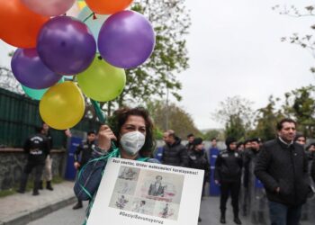 Διαδηλώτρια κρατά πανό με σκίτσα από στιγμιότυπα της δίκης του Οσμάν Καβαλά και ορισμένων από τους συγκατηγορούμενούς του(φωτ.: EPA/Erdem Sahin)