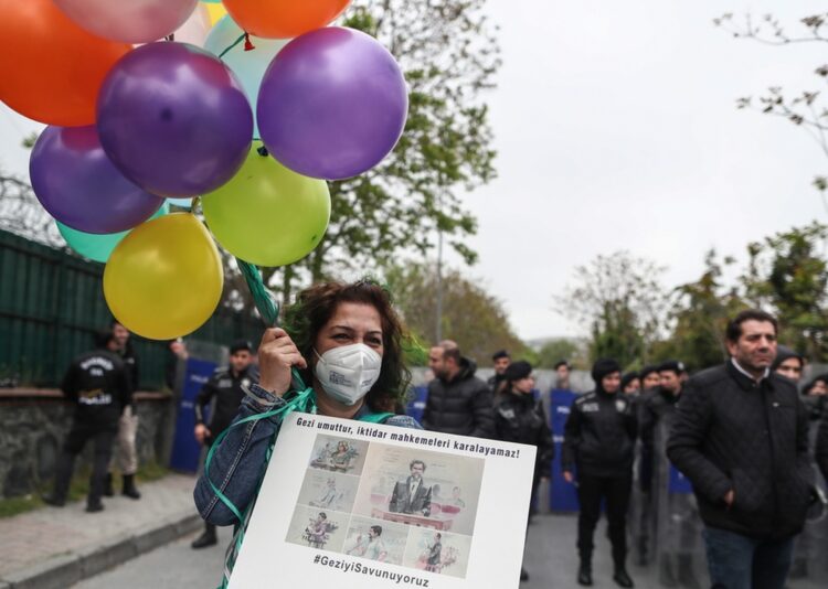 Διαδηλώτρια κρατά πανό με σκίτσα από στιγμιότυπα της δίκης του Οσμάν Καβαλά και ορισμένων από τους συγκατηγορούμενούς του(φωτ.: EPA/Erdem Sahin)