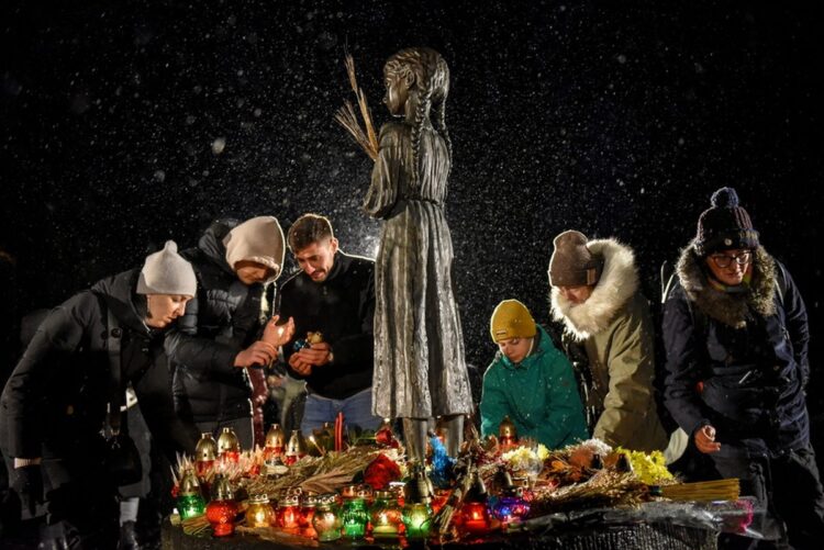 Ουκρανοί αφήνουν κεριά στο μνημείο του Χολοντομόρ, που σημαίνει η εξόντωση διά της πείνας στα ουκρανικά. (φωτ.: EPA/Oleg Petrasyuk)