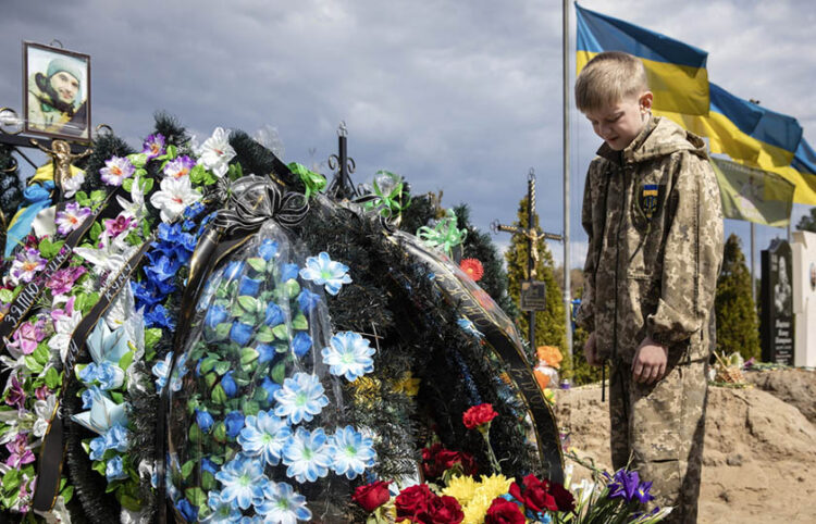 Ο 10χρονος Σεβέλιι στον τάφο του πατέρα του, ο οποίος σκοτώθηκε την 1η Μαΐου 2022 υπερασπιζόμενος το Ιρπίν (φωτ.: EPA / Mikhail Palinchak)