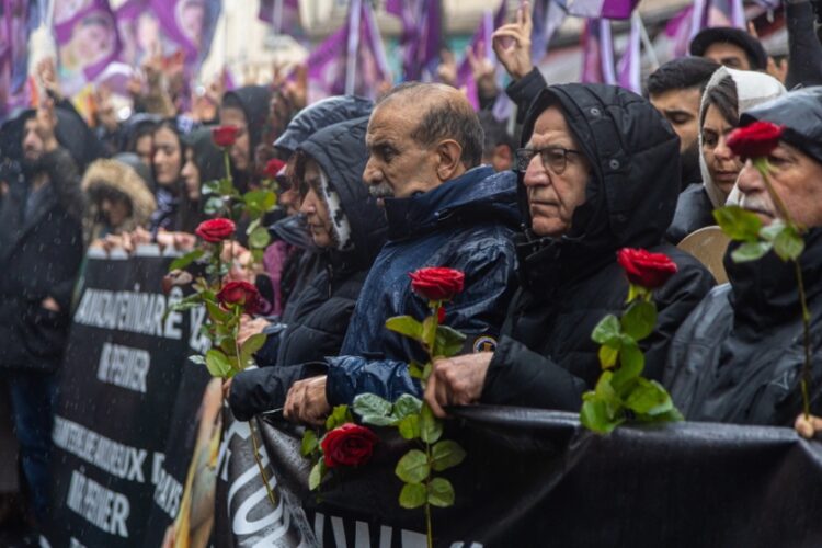 Μέλη της Κουρδικής κοινότητας, αλλά και πολίτες του Παρισιού κρατούν κόκκινα τριαντάφυλλα, στη διάρκεια ειρηνικής διαδήλωσης για τη δολοφονική επίθεση (φωτ. EPA/Christophe Petit Tesson)
