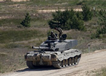 Βρετανοί στρατιώτες στη δύναμη του ΝΑΤΟ επιβαίνουν σε άρμα μάχης Challenger 2, στη διάρκεια στρατιωτικής άσκησης στη Λετονία, το 2020 (φωτ.: EPA/Valda Kalnina)