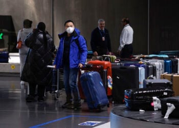 Ταξιδιώτες από την Κίνα στο αεροδρόμιο Ρουασί κοντά στο Παρίσι (φωτ.: EPA / Yoan Valat)