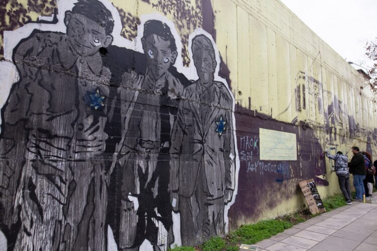 Πολίτες και μέλη της Ομάδας Γειτονιάς του Βαρδάρη καθαρίζουν τοιχογραφία που είναι αφιερωμένη στο Ολοκαύτωμα των Εβραίων στην περιοχή του Νέου Σιδηροδρομικού Σταθμού η οποία βανδαλίστηκε (φωτ.: ΑΠΕ-ΜΠΕ/Αχιλλέας Χήρας)