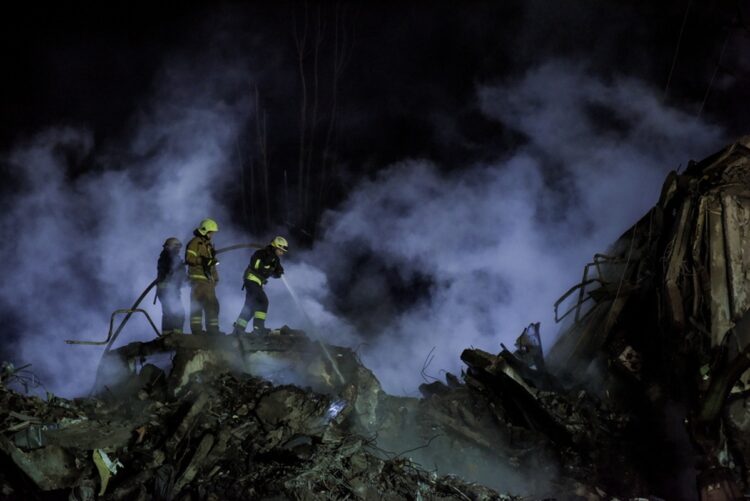 Πυροσβέστες στα συντρίμμια κτηρίου κατοικιών στο Ντνίπρο, μετά τη ρωσική επίθεση στην περιοχή (φωτ.: EPA/Oleg Petrasyuk)
