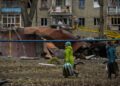 Πολίτες προσπερνούν συντρίμμια μετά από την πτώση ρωσικού πυραύλου στο Ντόνετσκ (φωτ.: EPA/Oleg Petrasyuk)