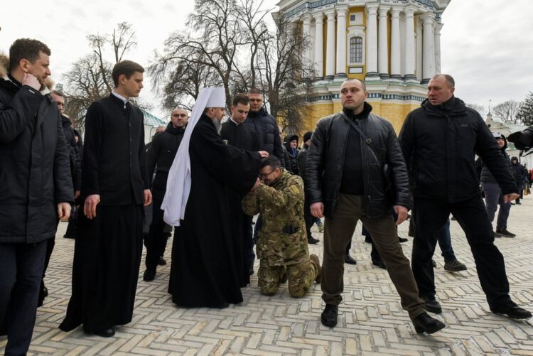 Ο προεξάρχων της Ουκρανικής Ορθόδοξης Εκκλησίας Μητροπολίτης Επιφάνιος ευλογεί έναν στρατιώτη, λίγο μετά από τη χριστουγεννιάτικη λειτουργεία στον ιερό ναό Κοιμήσεως της Θεοτόκου, στο Κίεβο (φωτ.: EPA/Oleg Petrasyuk)