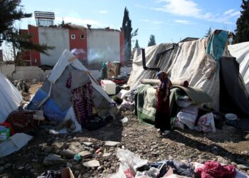 Θύματα του σεισμού στέκονται έξω από τις σκηνές, που πλέον αποτελούν το νέο σπίτι τους, στην Αντιόχεια. Στους καταυλισμούς δεν υπάρχουν ντους και οι λίγες τουαλέτες δεν επαρκούν για να καλύψουν τις ανάγκες (φωτ.: Tolga Bozoglu)