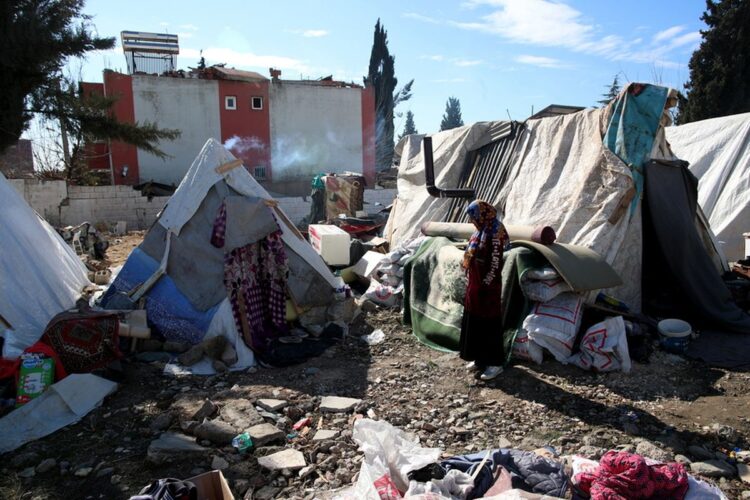 Θύματα του σεισμού στέκονται έξω από τις σκηνές, που πλέον αποτελούν το νέο σπίτι τους, στην Αντιόχεια. Στους καταυλισμούς δεν υπάρχουν ντους και οι λίγες τουαλέτες δεν επαρκούν για να καλύψουν τις ανάγκες (φωτ.: Tolga Bozoglu)