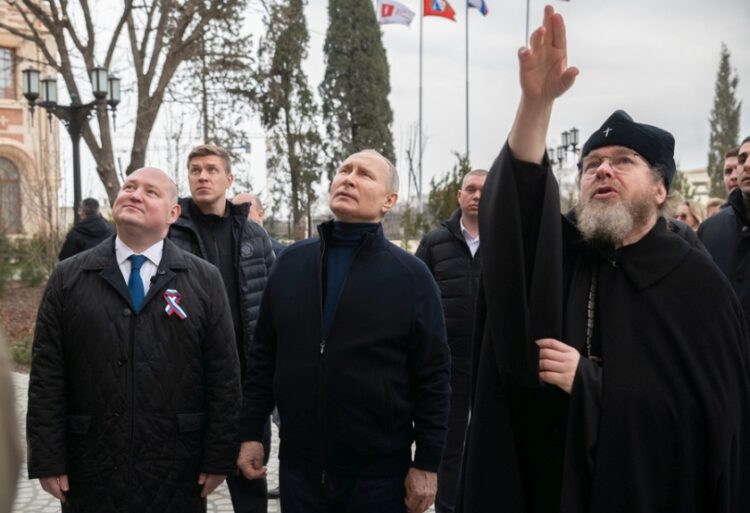 Ο κυβερνήτης της Σεβαστούπολης Mikhail Razvozhayev, ο Ρώσος πρόεδρος Βλαντιμίρ Πούτιν και ο μητροπολίτης Tikhon Shevkunov, πρόεδρος του Πατριαρχικού Συμβουλίου Πολιτισμού, επισκέπτονται ένα παιδικό κέντρο τέχνης και χειροτεχνίας, στην Κριμαία (φωτ.: EPA/ SPUTNIK/ KREMLIN POOL)