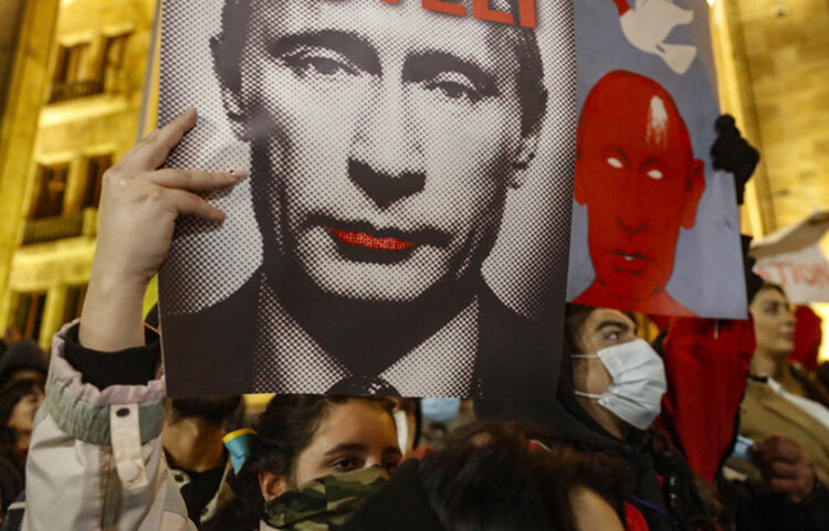 Διαδηλώτριες στο κέντρο της Τιφλίδας, κρατώντας φωτογραφίες του Βλαντίμιρ Πούτιν (φωτ.: EPA / Zurab Kurtsikidze)