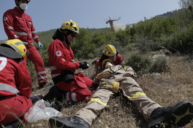 Διασώστες του Ερυθρού Σταυρού δίνουν τις πρώτες βοήθειες σε «τραυματία» πυροσβέστη, κατά τη διάρκεια άσκησης (φωτ.: ΑΠΕ-ΜΠΕ/Κώστας Τσιρώνης)