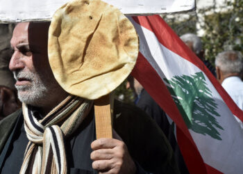 Διαδηλωτής έχει καρφώσει στο πλακάτ λιβανέζικο ψωμί (φωτ.: EPA / Wael Hamzeh)