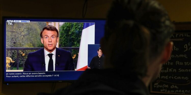 Άνδρας παρακολουθεί στην τηλεόραση σε μπαρ του Παρισιού τον Εμανουέλ Μακρόν να απευθύνει διάγγελμα προς το γαλλικό λαό (φωτ.: EPA/Teresa Suarez)
