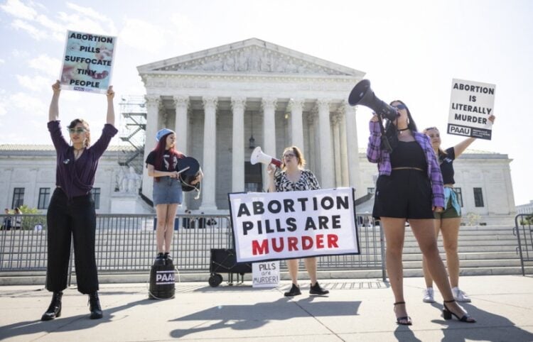 Αντίπαλοι της άμβλωσης διαμαρτύρονται έξω από το Ανώτατο Δικαστήριο των ΗΠΑ την ώρα που συνεδριάζει για την αναστολή περιορισμών στη χρήση του χαπιού για την άμβλωση (Φωτ.: EPA/Jim Lo Scalzo)