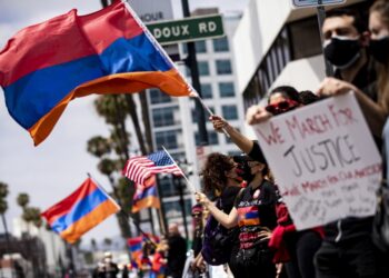 Αρμένιος διαδηλωτής κρατά πανό που αναγράφει «Κάνουμε πορεία για τη δικαιοσύνη, κάνουμε πορεία για τους προγόνους μας» κοντά στο τουρκικό προξενείο του Λος Άντζελες, στις ΗΠΑ, ανήμερα της επετείου της Γενοκτονίας των Αρμενίων το 2021 (φωτ.: EPA/Etienne Laurent)