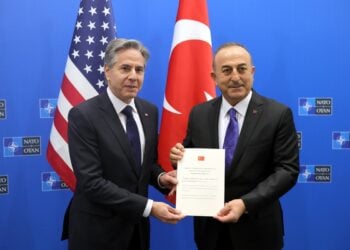 Ο Τούρκος υπουργός Εξωτερικών Μεβλούτ Τσαβούσογλου δίνει στον Αμερικανό ομόλογό του Άντονι Μπλίνκεν το έγγραφο επικύρωσης της προσχώρησης της Φινλανδίας στο ΝΑΤΟ (φωτ.: EPA/Olivier Matthys/POOL)